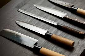 Set of knives with wooden handles on a wooden surface
